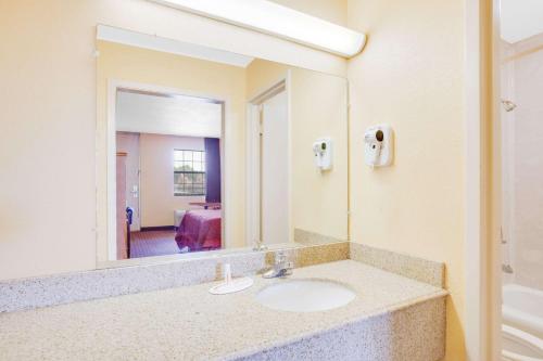a bathroom with a sink and a large mirror at Sunrise Extended Stay in Searcy