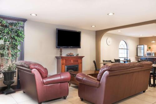 a living room with two leather chairs and a television at Days Inn by Wyndham New Braunfels in New Braunfels