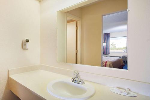 een badkamer met een wastafel en een grote spiegel bij Days Inn by Wyndham Greeneville in Greeneville