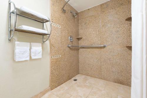 a bathroom with a shower with white towels at Days Inn by Wyndham Dalhart in Dalhart