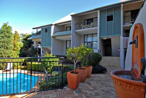 an apartment building with a swimming pool and plants at Spring Hill Mews Apartments in Brisbane