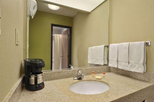 uma casa de banho com um lavatório e comodidades para preparar café em Days Inn by Wyndham Carlsbad em Carlsbad