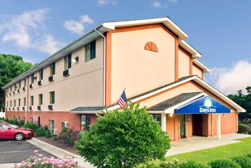 a building with an american flag in front of it at Days Inn by Wyndham Torrington in Torrington