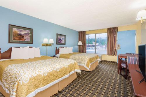a hotel room with two beds and a balcony at Days Inn by Wyndham Clayton in Clayton