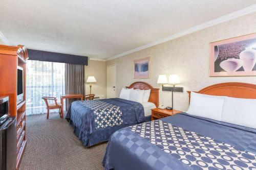 a hotel room with two beds and a television at Days Inn by Wyndham Los Angeles LAX/VeniceBch/Marina DelRay in Los Angeles