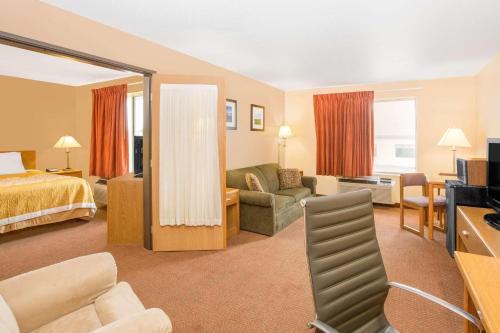a hotel room with a bed and a living room at Days Inn by Wyndham Worthington in Worthington