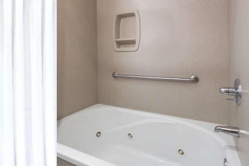 a white bath tub in a bathroom with a window at Days Inn by Wyndham Sidney NE in Sidney