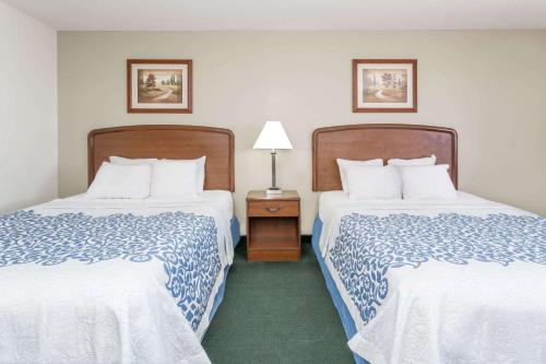 a hotel room with two beds and a table with a lamp at Days Inn by Wyndham Sidney NE in Sidney