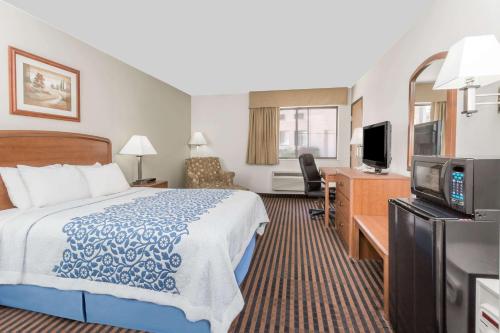 a hotel room with a bed and a flat screen tv at Days Inn by Wyndham Sidney NE in Sidney
