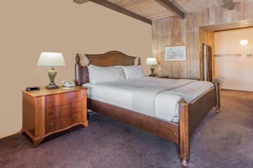 een slaapkamer met een bed en een nachtkastje met 2 lampen bij Days Inn by Wyndham West Allis/Milwaukee in West Allis