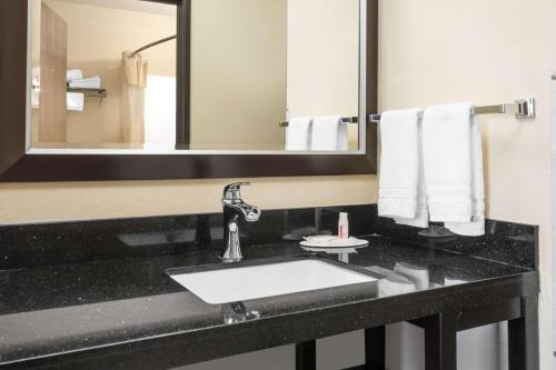 a bathroom with a sink and a mirror at Days Inn by Wyndham North Platte in North Platte