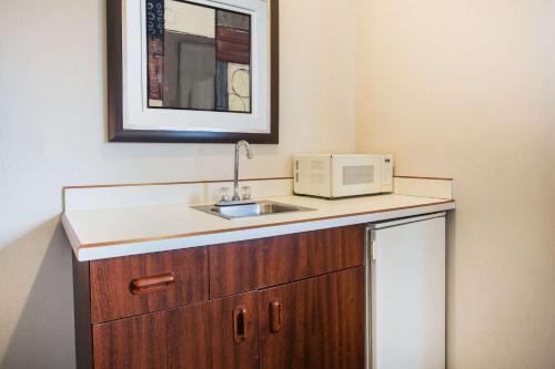 a kitchen with a sink and a microwave on a counter at Days Inn by Wyndham Seattle Aurora in Shoreline