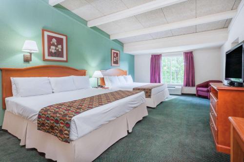 ein Hotelzimmer mit 2 Betten und einem Flachbild-TV in der Unterkunft Days Inn & Suites by Wyndham Lexington in Lexington