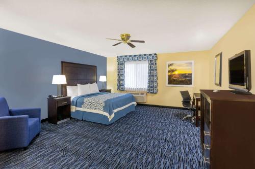 a hotel room with a bed and a flat screen tv at Days Inn by Wyndham Moab in Moab