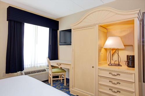 um quarto de hotel com uma cama e uma secretária em Windsor Hotel em East Windsor