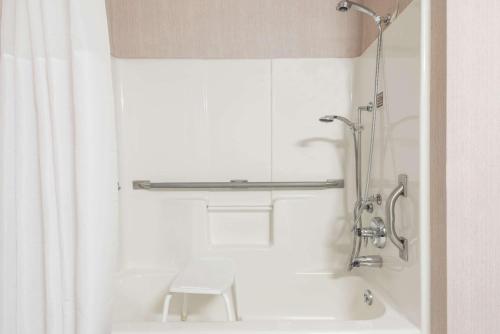 uma casa de banho com um chuveiro e uma banheira branca em Days Inn by Wyndham Carbondale em Carbondale