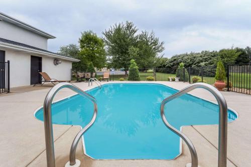 a swimming pool with blue water in a yard at Days Inn by Wyndham Battlefield Rd/Hwy 65 in Springfield