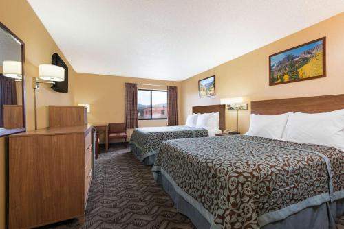 a hotel room with two beds and a flat screen tv at Days Inn by Wyndham Carbondale in Carbondale