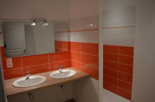a bathroom with two sinks and a mirror at Ferme Passion in Saint-Trivier-sur-Moignans