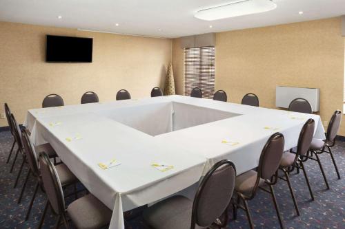 a conference room with a large white table and chairs at Days Inn by Wyndham Brantford in Brantford