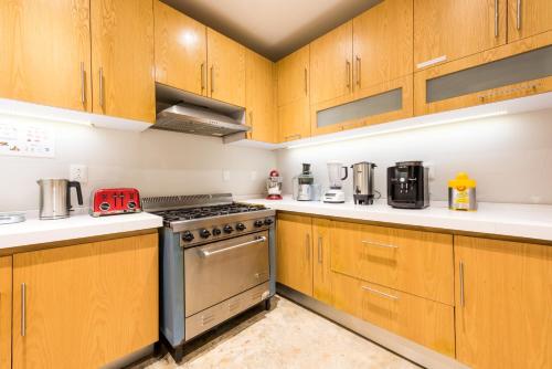 a kitchen with wooden cabinets and a stove at La Palomilla Bed & Breakfast in Mexico City
