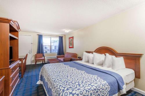 a hotel room with a bed and a television at Days Inn by Wyndham Dover Downtown in Dover