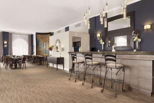 a restaurant with a bar with chairs and tables at Days Inn by Wyndham Montreal Airport Conference Centre in Dorval