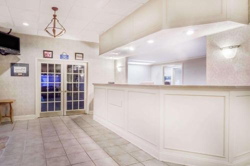 a large kitchen with white cabinets and a counter at Days Inn by Wyndham Dover Downtown in Dover