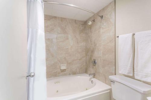 a bathroom with a shower and a tub and a toilet at Days Inn by Wyndham Winston Salem North in Winston-Salem