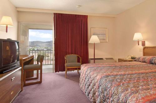 a hotel room with a bed and a flat screen tv at Days Inn by Wyndham Colorado Springs/Garden of the Gods in Colorado Springs