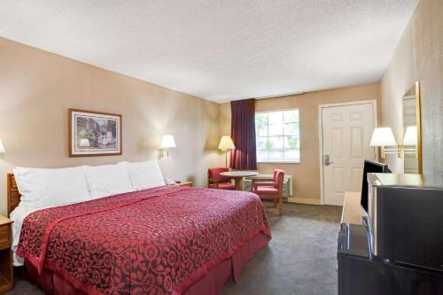 ein Hotelzimmer mit einem Bett und einem TV in der Unterkunft Days Inn by Wyndham Joelton/Nashville in Joelton