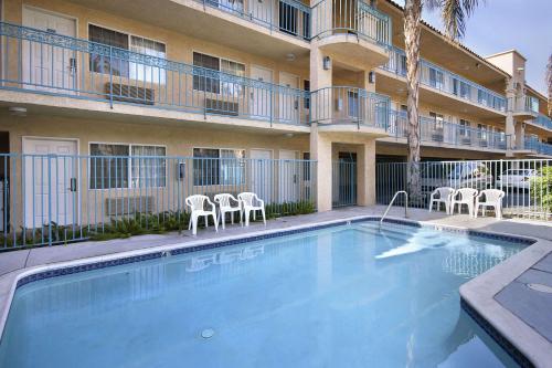 a swimming pool in front of a building with chairs at Days Inn by Wyndham Riverside Tyler Mall in Riverside