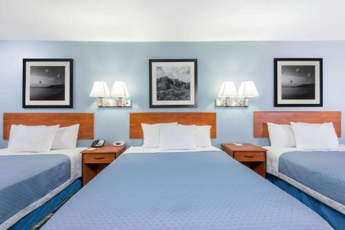 two beds in a room with blue walls at Days Inn by Wyndham Las Vegas in Las Vegas