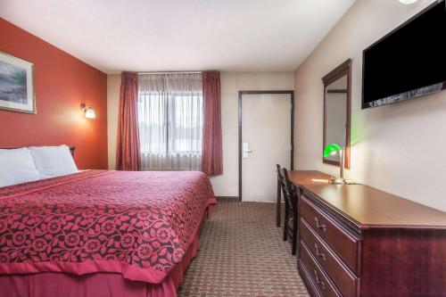 a hotel room with a bed and a flat screen tv at Red Carpet Inn Elkton in Elkton