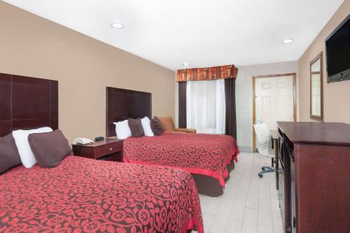 um quarto de hotel com duas camas e uma televisão de ecrã plano em Days Inn by Wyndham Arcadia em Arcadia