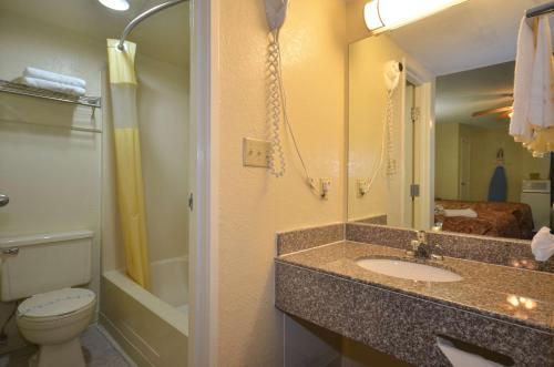 y baño con lavabo, aseo y ducha. en Days Inn by Wyndham Southern Hills/ORU, en Tulsa