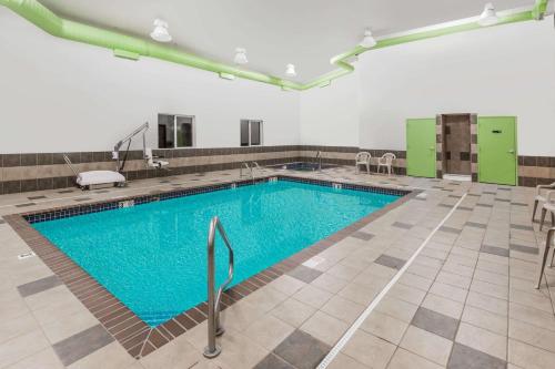 a swimming pool with a pool table and chairs at Econo Lodge Inn & Suites in Yankton