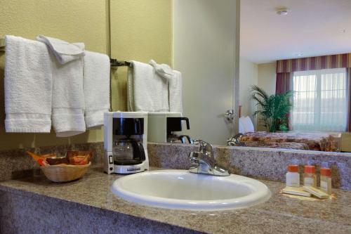 a bathroom counter with a sink with a coffee maker on it at Days Inn by Wyndham Hayward Airport in Hayward
