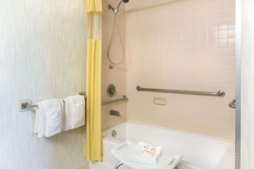 a bathroom with a shower and a tub and a toilet at Days Inn by Wyndham Richmond in Richmond