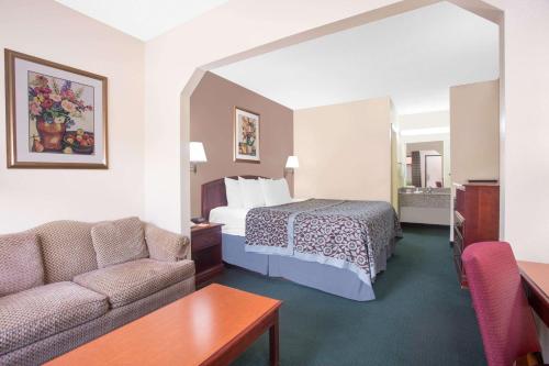 Habitación de hotel con cama y sofá en Days Inn by Wyndham Dublin GA en Dublin