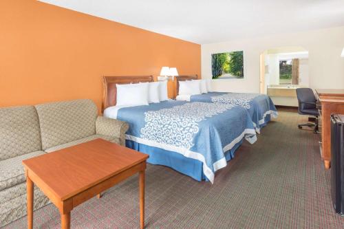 a hotel room with a bed and a couch at Days Inn by Wyndham Orangeburg South in Orangeburg
