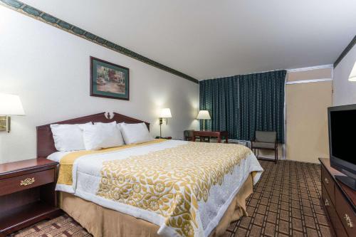 a hotel room with a bed and a flat screen tv at Days Inn by Wyndham Dickson in Dickson