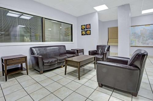 a waiting room with leather chairs and a table at Days Inn by Wyndham Norfolk Military Circle in Norfolk