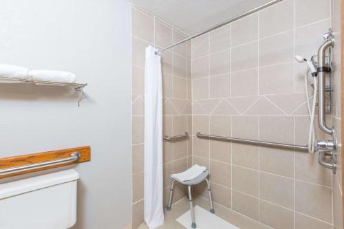 a bathroom with a shower and a toilet at Days Inn by Wyndham Hays in Hays