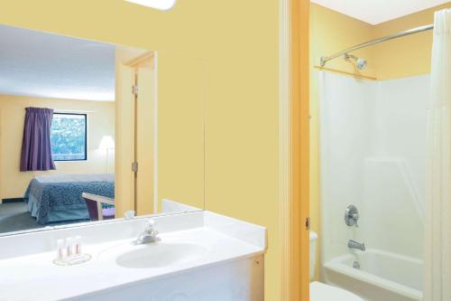 a bathroom with a sink and a mirror at Days Inn by Wyndham Camilla in Camilla