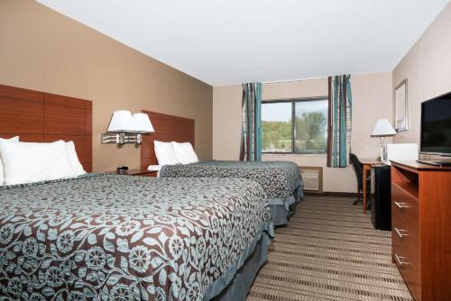 a hotel room with two beds and a flat screen tv at Days Inn by Wyndham Mankato in Mankato