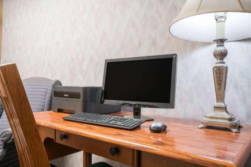 a computer monitor and a keyboard and mouse on a desk at Days Inn by Wyndham Hurley in Hurley