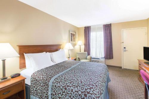 a hotel room with a bed and a television at Days Inn by Wyndham Ripley in Ripley