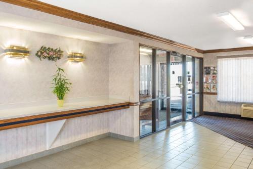 a lobby with a waiting area with a plant on the wall at Days Inn by Wyndham Pontoon Beach in Pontoon Beach