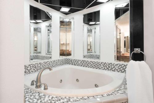 uma banheira numa casa de banho com vários espelhos em Days Inn by Wyndham St Clairsville em Saint Clairsville